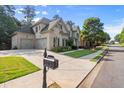 Suburban home featuring a three-car garage and a well-maintained lawn at 10565 Highgate Manor Ct, Duluth, GA 30097