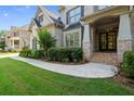 Welcoming entrance to a brick home featuring a manicured lawn and beautiful landscaping at 10565 Highgate Manor Ct, Duluth, GA 30097
