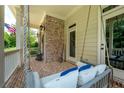 Inviting front porch with brick accents featuring a brick floor and relaxing porch swing at 6105 Overlook Park Dr, Cumming, GA 30040