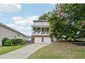 Charming two-story home featuring a covered porch with a white railing and a blooming tree in the yard at 218 South Se Ave, Atlanta, GA 30315