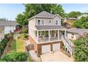 Exterior view of a two-story home with a front porch, beautiful landscaping, and an attached two-car garage at 218 South Se Ave, Atlanta, GA 30315