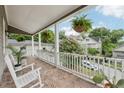 View of a covered front porch featuring brick flooring, hanging plants, and comfortable seating at 218 South Se Ave, Atlanta, GA 30315