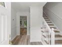 Bright entryway with hardwood flooring and white staircase with wood stairs at 4220 Singing Post Ne Ln, Roswell, GA 30075
