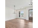 Spacious dining room with modern chandelier, wood floors, and a bright window at 6450 Pond View Dr, Cumming, GA 30028