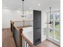 Bright loft features hardwood floors, black metal railing, and built in shelving at 6450 Pond View Dr, Cumming, GA 30028