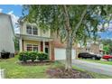 A brick and vinyl home has manicured bushes and a tree in the front yard and a two car garage at 2280 Copper Trail Ln, Buford, GA 30519