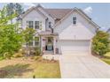 Inviting two-story home featuring white siding, a two-car garage, and a well-manicured lawn and garden at 28 Rolling Rock Way, Dallas, GA 30157
