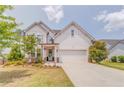 Charming two-story home with white siding, a well-manicured lawn, and a welcoming front entrance at 28 Rolling Rock Way, Dallas, GA 30157