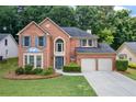 Inviting brick home featuring a two-car garage and manicured front lawn at 3652 Morning Creek Ct, Suwanee, GA 30024
