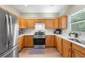 Well-lit kitchen featuring stainless steel appliances and light wood cabinets at 3652 Morning Creek Ct, Suwanee, GA 30024