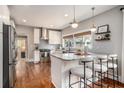 Modern kitchen boasts stainless steel appliances, granite countertops, an island with bar seating, and hardwood floors at 583 Etowah Ne Dr, Marietta, GA 30060