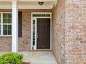 Close-up of a brick facade with a solid brown front door, sidelights, and white trim at 181 Ridgemont Rd, Canton, GA 30114