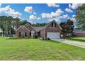 Charming brick home features a well-manicured lawn and attached two-car garage, set beneath a beautiful sky at 2790 Meadow Gate Way, Loganville, GA 30052