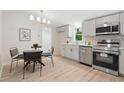 Eat-in kitchen boasts stainless appliances, modern lighting, white cabinets and countertops at 1010 Martin Ln, Canton, GA 30114
