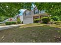 Two-story home with a well-maintained lawn, inviting blue door, and attached garage at 207 Diamond Valley Pass, Canton, GA 30114