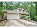 Two-story home featuring a two-car garage and a cozy front porch surrounded by lush landscaping at 3025 Mountain Creek Ne Ct, Roswell, GA 30075