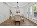 Elegant dining room featuring modern chandelier, large windows, and wood-look flooring at 303 Ridgewood Trl, Canton, GA 30115
