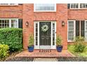 Close-up of the front door showcasing a welcoming wreath, flanking potted plants, and stylish sconces at 3990 Madison Main Nw, Kennesaw, GA 30144