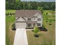 Stunning aerial view of a white home with a three car garage and beautiful landscaping at 7345 Vale Ct, Cumming, GA 30028