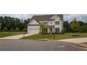 Beautiful two-story home with a gray roof, a large lawn, and a three car garage at 7345 Vale Ct, Cumming, GA 30028