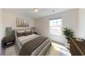 Comfortable bedroom with neutral decor, featuring a large window, plush carpet, and a stylish bed at 333 Torcello Blvd, Mcdonough, GA 30253