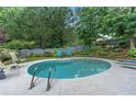 Backyard swimming pool with lounge chairs, landscaping, and privacy fence is great for relaxing and entertaining at 648 York View Dr, Auburn, GA 30011