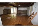 Spacious living room with hardwood floors, a stone fireplace, and double doors leading outside at 352 Price Rd, Carrollton, GA 30116