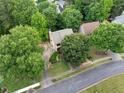 Aerial view of a charming home nestled among mature trees on a well-maintained street at 404 Pine Grove Way, Woodstock, GA 30189