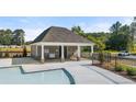 Community pool area featuring a modern pool house with covered seating and ample parking at 1307 Aura Ln, Lawrenceville, GA 30045