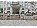 Elegant building entrance with stone steps, lush planters, and clear signage at 3445 Stratford Ne Rd # 2703, Atlanta, GA 30326