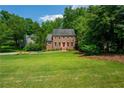 A charming two-story brick home nestled among mature trees with a well-maintained lawn at 1885 N Creek Cir, Alpharetta, GA 30009