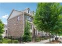 Inviting brick townhome with a gated yard, mature tree, and a beautifully landscaped entryway at 4012 Townsend Ln, Dunwoody, GA 30346