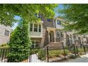 Brick townhome boasting a multi-story design, well-kept landscaping, and a secure, gated front yard at 4012 Townsend Ln, Dunwoody, GA 30346