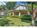 Charming gray two-story home featuring a well-manicured lawn, lush landscaping, and inviting front porch at 629 2Nd Avenue, Decatur, GA 30030