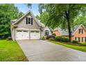 Stucco home featuring a two-car garage, lush lawn and attractive landscaping at 1010 Longcreek Pointe, Alpharetta, GA 30005