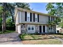 Two-story townhome featuring gray siding, stone accents, and black shutters at 1140 Forest Villa Nw Dr, Conyers, GA 30012