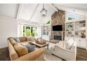Bright living room featuring a stone fireplace, vaulted ceilings, and built-in shelving at 7114 Surrey Pt, Alpharetta, GA 30009