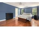 Spacious main bedroom with hardwood floors, a ceiling fan, and two windows at 325 Meadows Ln, Canton, GA 30114