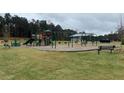 Community playground featuring various slides, swings, and play structures with benches and green space at 5370 Tolar Rd, South Fulton, GA 30213