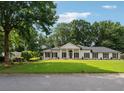 Inviting exterior view of home featuring a lush green lawn and mature trees at 5631 Queensborough Dr, Atlanta, GA 30338