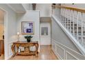 Inviting foyer with hardwood floors, staircase, wainscoting, and elegant decorative table at 785 Cirrus Dr, Johns Creek, GA 30022