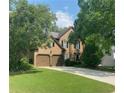 Charming two-story home featuring a well-manicured lawn and inviting entryway with lush landscaping and a two car garage at 3570 Bardfield Ct, Cumming, GA 30041