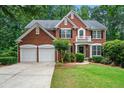 Beautiful two-story brick home featuring a well-kept lawn and double garage at 1115 Ballington Dr, Cumming, GA 30041