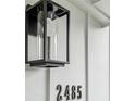 Close-up of house numbers and modern black exterior light fixture against white siding at 2485 Hillside Ave, Decatur, GA 30032