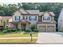 Inviting two-story home boasting a brick facade, two-car garage, landscaped front yard, and covered entrance at 2525 Well Springs Dr, Buford, GA 30519