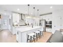 Bright, modern kitchen with stainless steel appliances, white cabinets, a center island, and barstool seating at 5769 Tillman Way, Powder Springs, GA 30127