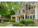 Beautiful home exterior with a covered porch and lush landscaping creates a welcoming atmosphere at 1205 Compass Pointe Xing, Alpharetta, GA 30005