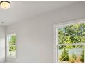 Bedroom with large windows offering natural light and a view of the surrounding greenery at 6520 Pond View Dr, Cumming, GA 30028