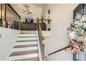 Bright entryway featuring stairs leading to a spacious living area with carpeted floors and a comfortable couch at 79 Little Creek Manor Dr, Dallas, GA 30157