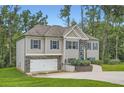 Two-story home with stone accents, blue shutters, a well-kept lawn, attached garage, and set among mature trees at 79 Little Creek Manor Dr, Dallas, GA 30157